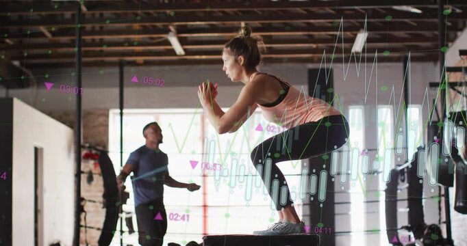 Woman performing squat jumps and stepups on box in gym, timer starting and charts tracking reps