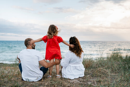 Family spending quality time at beach against cloudy sky