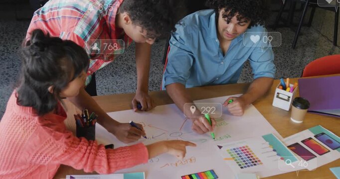Design team drawing circle, sketching mind map, choosing colors while social icons overlaying