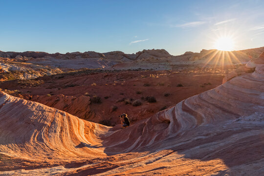 USA, Nevada, Valley of Fire State Park, woman taking pictures of colored sandstone and limestone rocks of the Fire Wave