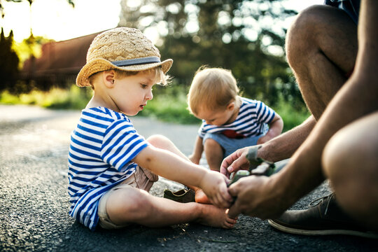Father assisting his little son undressing his shoes