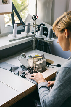 Woman using sewing machine on table in studio