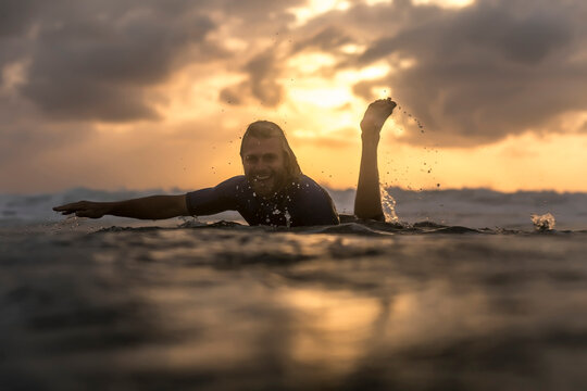 Indonesia, Bali, surfer in the ocean at sunrise
