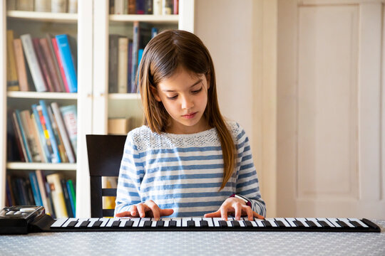 Girl playing roll piano at home