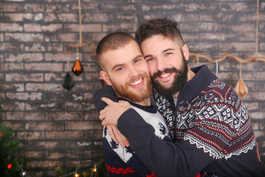 Portrait of happy gay couple embracing at Christmas