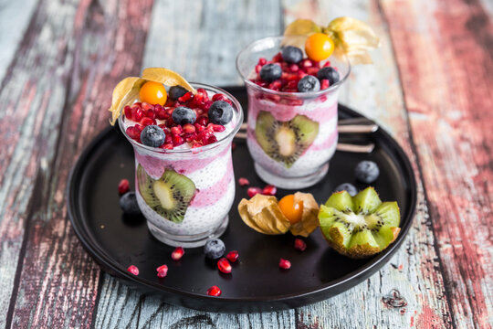 Two glasses of chia pudding with several fruits