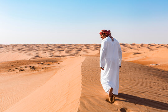 Bedouin walking in the desert, Wahiba Sands, oman