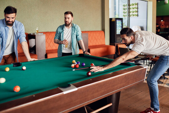 Friends playing billiards together