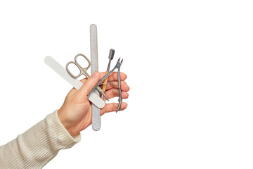 Hand holding a variety of nail care instruments for beauty and grooming