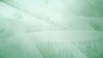 Soft light green crumpled gauze fabric texture background