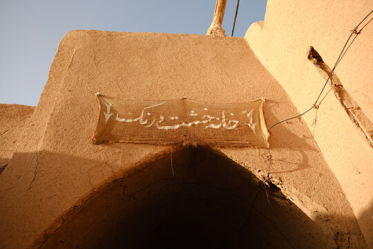 Traditional mudbrick archway with Persian sign in Yazd Iran