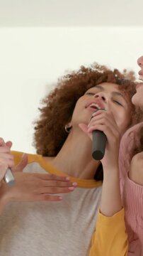 Vertical video: Opening frame on singer with mic, singing lead at home, dueting with denim jacket