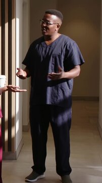Vertical video: Responding to colleague offering coffee, doctor in scrubs gesturing in clinic hall