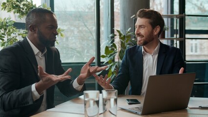 Two diverse businessmen business team happy discuss good online news ecxited men Caucasian man...