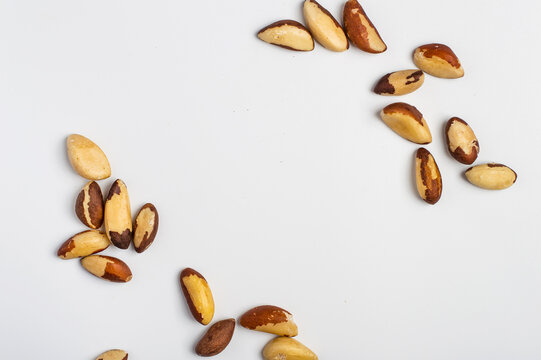 Brazil nuts in large quantities on light background, top view, free space, organic healthy food, natural snack, superfood rich in selenium.