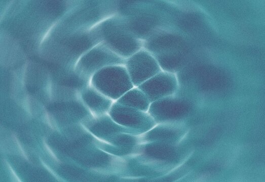Abstract turquoise water caustic pattern with soft ripples and grain texture