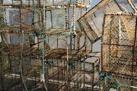 View of stacked, weathered fishing traps, a testament to the coastal life, with their nets and frames creating a textured mosaic, Angeiras, Lavra, Portugal.