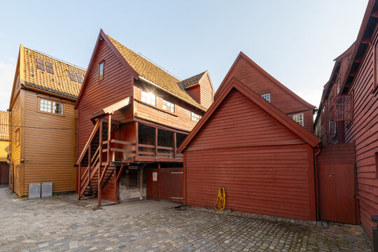 View of vibrant red and orange wooden buildings, a timeless testament to history, standing proudly against the clear sky, Bergen, Norway., Bergen, Norway.