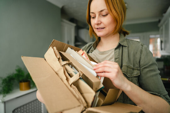 Woman sorting cardboard for recycling in a sustainable household