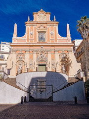 Fototapeta premium Low angle view of the Baroque Chiesa di Santa Teresa a Chiaia in Naples. Ornate stucco details and stone stairs in the historic Chiaia district. Travel in Italy.