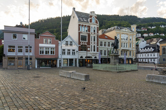 View of Ludvig Holberg statue standing proudly amidst the colorful facades of historic buildings under a serene sky, Bergen, Vestland, Norway.