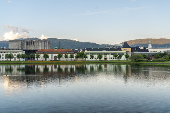 View of tranquil Lille Lundgegardsvannet mirroring the buildings and trees under a serene sky, a scenic vista of urban integration with nature, Bergen, Vestland, Norway.
