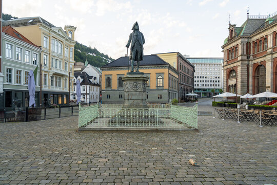 View of Ludvig Holberg statue stands tall in a cobblestone square, framed by ornate buildings and soft daylight, Bergen, Vestland, Norway.
