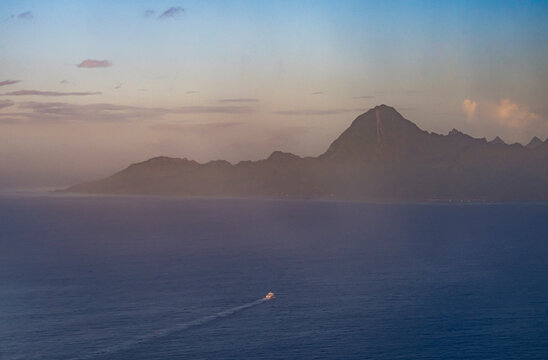 Aerial view of Moorea island and ocean with boat at sunset