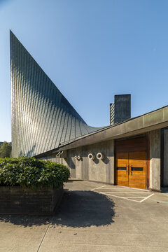 View of striking modern Slettebakken Church with a soaring, angular metallic roof contrasts against the clear blue sky, Bergen, Vestland, Norway.