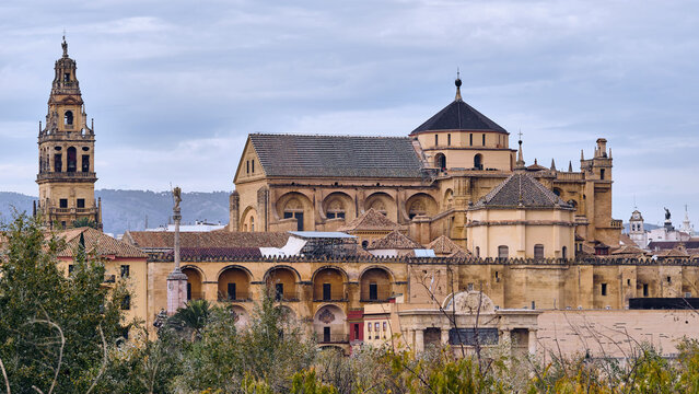 View of the Mezquita-Cathedral's striking bell tower piercing the skyline amidst ancient walls, a testament to time's passage, Cordoba, Andalusia, Spain.