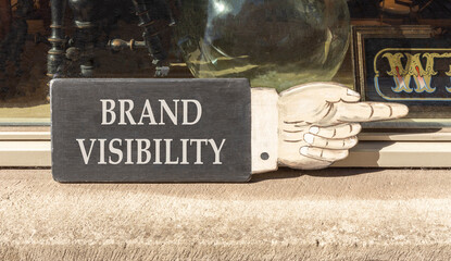 Brand visibility symbol. Concept words Brand visibility on beautiful wooden black sign as a hand....