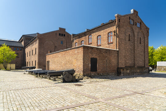 View of old cannons standing guard before a weathered Norwegian Armed Forces Museum
 brick building, Oslo, Oslo, Norway.