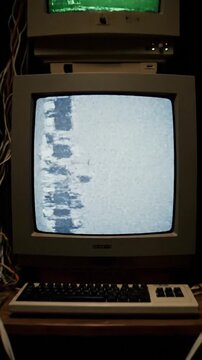 Vintage electronic equipment and monitors fill a cluttered room