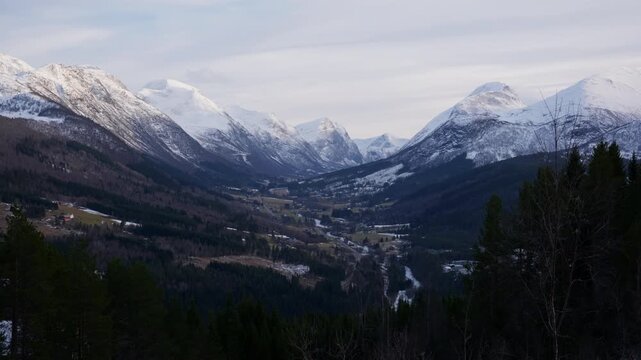 Scenic shot of Stranda dalen, a valley in Norway with beautiful scenery and tall mountains covered with snow on a bright sunny day