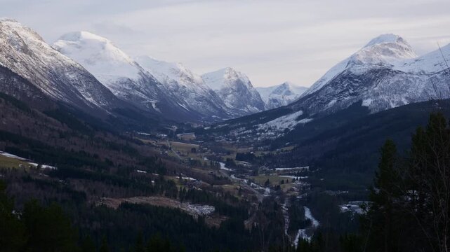 Scenic shot of Stranda dalen, a valley in Norway with tall mountains covered with snow and a beautiful scenery on a bright winter day