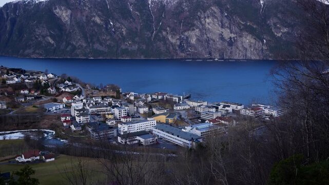 Scenic shot of Stranda, a small town in Norway surrounded by mountains and fjords on a bright day