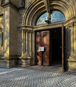 Church is open german text near wooden door