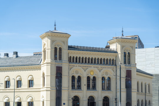 View of the Nobel Peace Center stands majestically against a clear blue sky, its beige facade adorned with intricate architectural details, Oslo, Oslo, Norway.