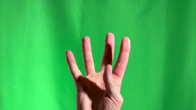 Counting fingers. Hand gesture, sign. Close-up on chromakey green background.