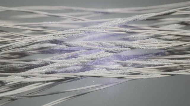 Medium shot showing nitrogen plasma modification on textile fibers creating reactive sites to improve chemical bonding and durability in fabric applications.