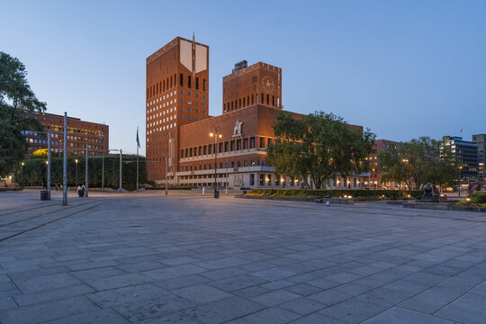 View of Oslo City Hall, a striking brick building, stands tall against the deepening twilight sky, a blend of history and modernity, Oslo, Norway.