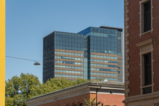 View of modern architecture meets historical brickwork under a serene blue sky, contrasting textures and eras in the heart of the city, Oslo, Oslo, Norway.