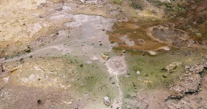 Volcanic pit with mud and boiling water with steam rising to the surface in a pond at Furnas, Azores.