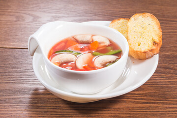 A single scallop shell filled with steamed scallop topped with garlic, vermicelli, and green onion...