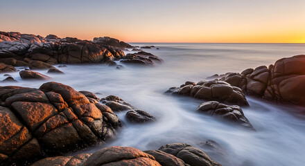 Obraz premium Rocky Shoreline Sunrise Long Exposure Smooth Water Mist