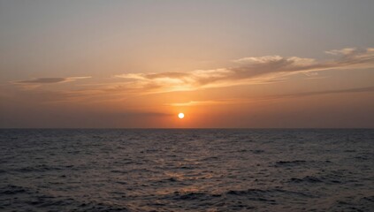 Obraz premium Scenic view of the sunset over the ocean with wispy clouds in the colorful sky