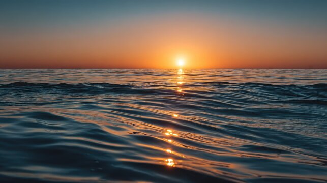 Golden sunset over calm ocean horizon with glowing reflections on gentle waves, peaceful coastal landscape capturing warm evening light and serene atmosphere