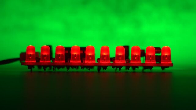 Running light sequence on row of red LEDs with green illuminated background.