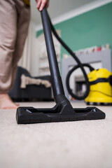 Fototapeta premium Vacuuming the floor. Close up of vacuum cleaner, living room. Household and useful technology lifestyle. Copy space
