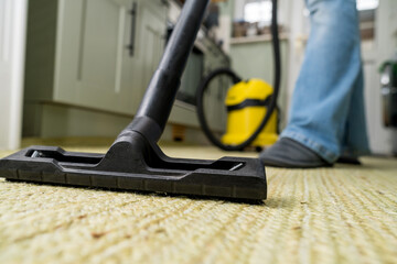Fototapeta premium Vacuuming the floor. Close up of vacuum cleaner, kitchen. Household and useful technology lifestyle. Copy space